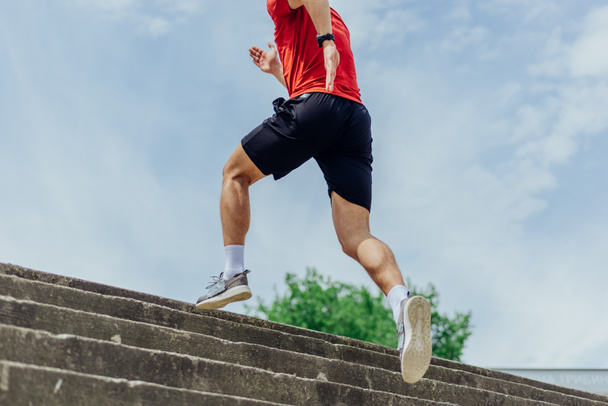 Fit mannelijke atleet uitvoeren van trap workout, lopen naar boven trappen uitvoeren outdoor track cardio. - Foto, afbeelding