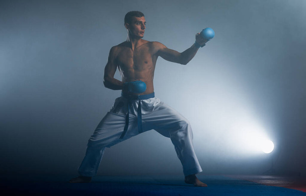 Siyah kuşaklı karateci poz veriyor, dünya şampiyonu siyah arka planda çekim yapıyor. - Fotoğraf, Görsel