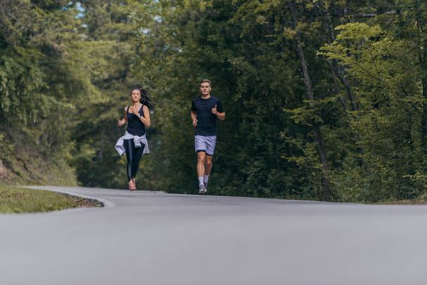 Casal atlético correndo em uma rua ao lado um do outro. Natureza, ajuste e conceito saudável. - Foto, Imagem