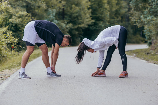 Male and female athletes preparing for a marathon, run, workout. Healthy lifestyle concept. - Foto, afbeelding