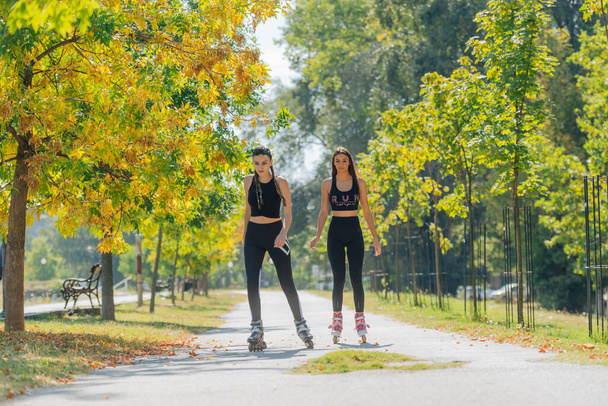 Koko kehon muotokuva onnellisista urheilijoista rullaluistelu puistossa aurinkoisena päivänä - Valokuva, kuva