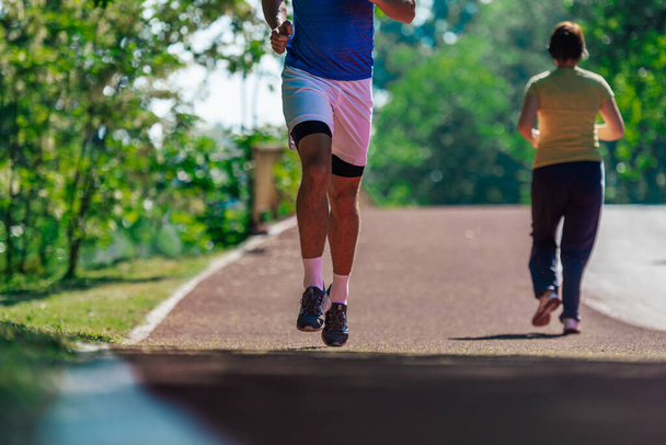 Fermez les pieds avec des chaussures de course et de fortes jambes athlétiques de jogging homme de sport sur la piste de course - Photo, image