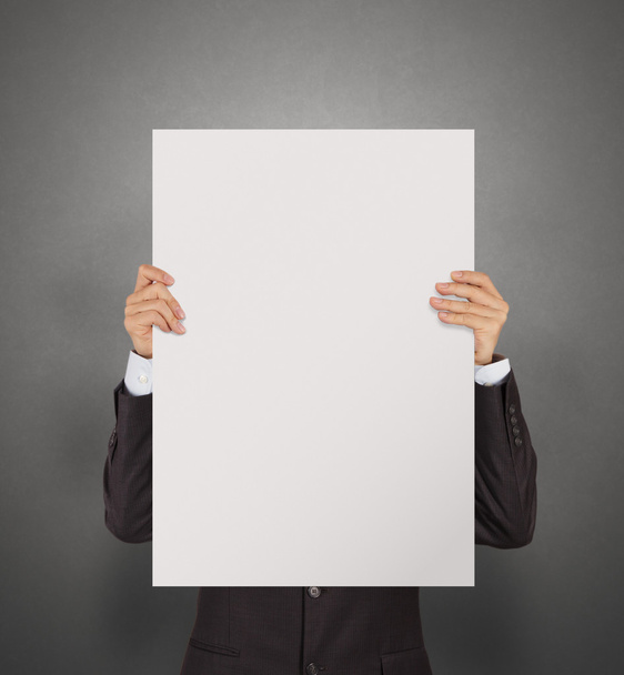 businessman holding blank poster on texture wall as concept  - Photo, Image