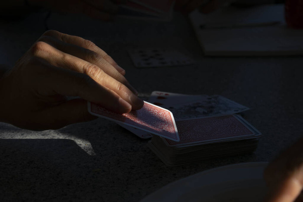 A man taking a playing card from the deck of cards in the darkness -gambling - Fotoğraf, Görsel
