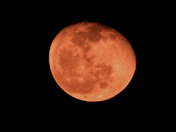 Nahaufnahme von Orange Color Moon isoliert schwarzen Hintergrund. Roter Mond, auch als Blutmond bekannt, eine Mondfinsternis, bei der der Mond eine rote Farbe bekommt - Foto, Bild