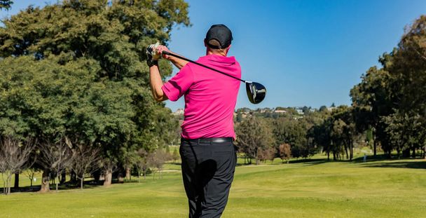 A professional athlete playing golf on a warm sunny day - 写真・画像