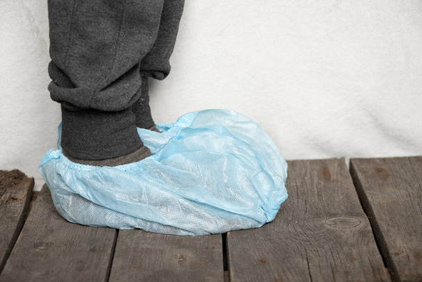 jambes féminines en bleu médical protecteur couvre-chaussures en plastique à l'hôpital - Photo, image