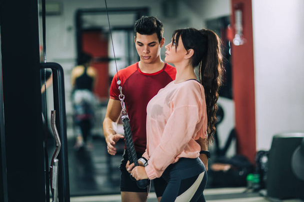 Fitness instructor with girl on training in fitness center - Photo, Image