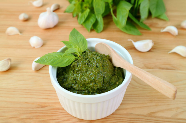Tasty and Healthy Homemade Fresh Basil Pesto Sauce in White Bowl with a Wooden Spoon - Photo, Image