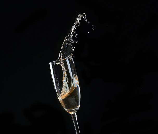 Glass of champagne with splash, on black background - Fotografie, Obrázek