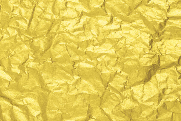Valaiseva kultainen paperi rakenne. Ryppyinen folio tausta. Vuoden väri 2021. - Valokuva, kuva