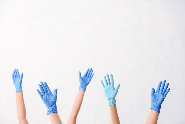 Handen in beschermende handschoenen op witte achtergrond - Foto, afbeelding