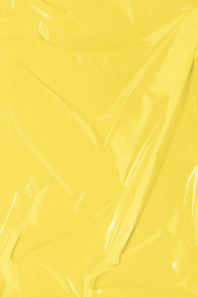 Illuminant jaune Film adhésif froissé, texture plastique, fond vinyle. Couleur de l'année 2021. - Photo, image