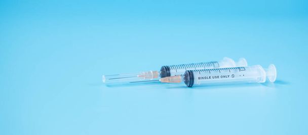 injection Needle Syringe on blue background in hospital laboratory. Medical, health, Vaccination and immunization concept - Photo, Image