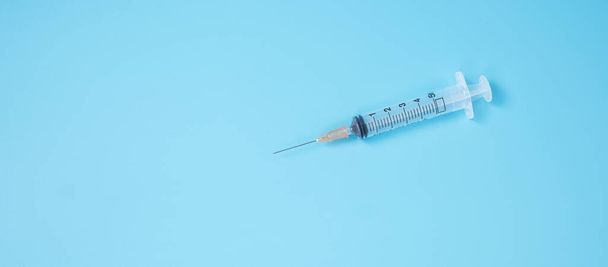 seringue d'aiguille d'injection sur fond bleu en laboratoire hospitalier. Concept médical, santé, vaccination et immunisation - Photo, image
