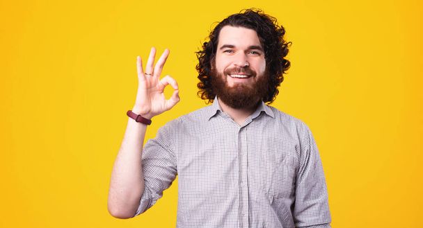 Portré boldog vidám férfi göndör haj mutatja rendben gesztus - Fotó, kép