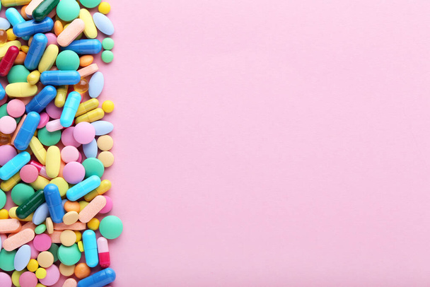 Colorful pills on pink background - Фото, изображение