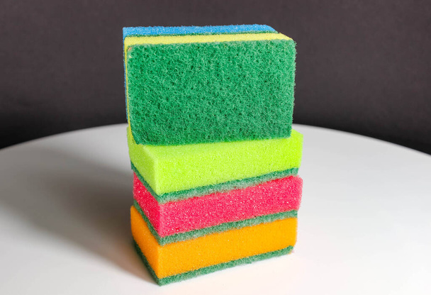 several household sponges of different colors. Close-up, selective focus. - Фото, изображение