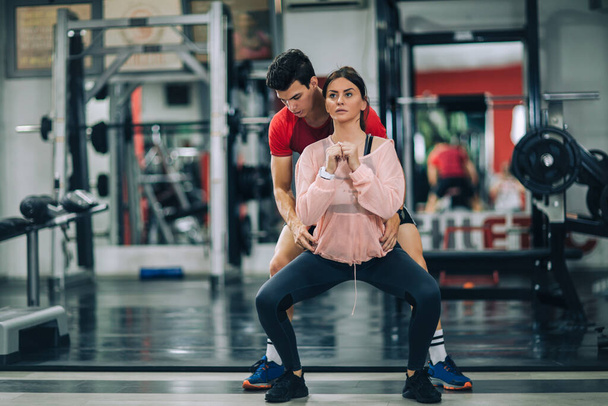 Istruttore di fitness con ragazza in allenamento nel centro fitness - Foto, immagini
