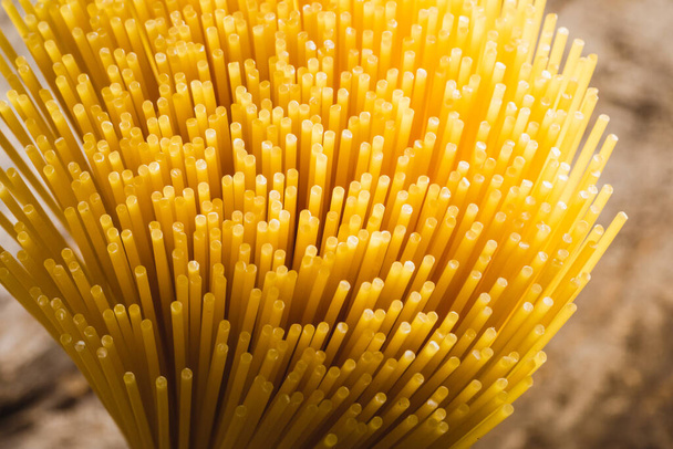 close up of yellow long spaghetti. Yellow italian pasta. Raw spaghetti. Food background concept. - Foto, Imagen