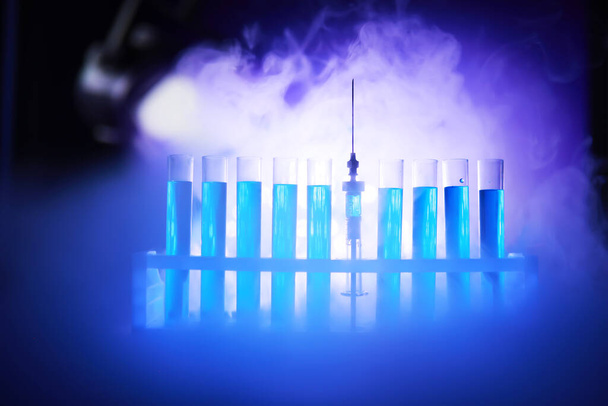 Tubo de ensayo de vidrio desborda nueva solución líquida azul de potasio lleva a cabo una reacción de análisis toma varias versiones reactivos utilizando productos químicos farmacéuticos fabricación de cáncer  - Foto, Imagen