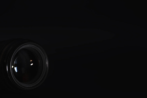 Οπτική στην κάμερα στο γραφείο των χειριστών. Λάμψη στο γυαλί ενός φωτογραφικού φακού. Μαύρο φόντο με την τεχνική του φωτογράφου.  - Φωτογραφία, εικόνα
