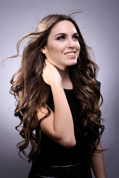 Beautiful young woman with long hair on grey background - Φωτογραφία, εικόνα