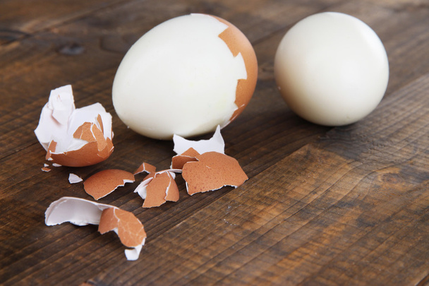 Peeled boiled egg on wooden background - Фото, изображение