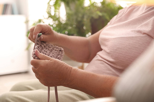 Elderly woman crocheting at home, closeup. Creative hobby - Zdjęcie, obraz