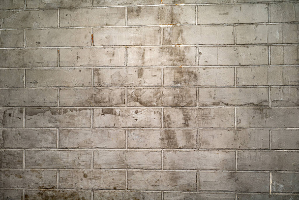 Un vieux mur de briques sales de couleur grise. Fond d'un mur de briques blanches épluchantes. - Photo, image