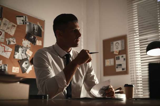Detective working at desk in his office - Foto, Imagen