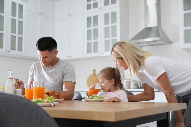 Happy family having breakfast together at table in modern kitchen - Fotoğraf, Görsel