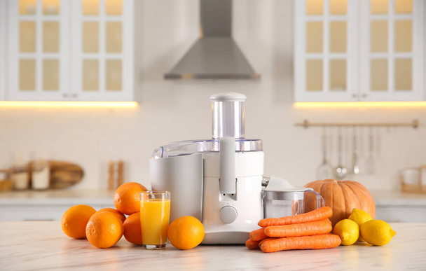Modern juicer, fresh vegetables and fruits on table in kitchen - Фото, изображение