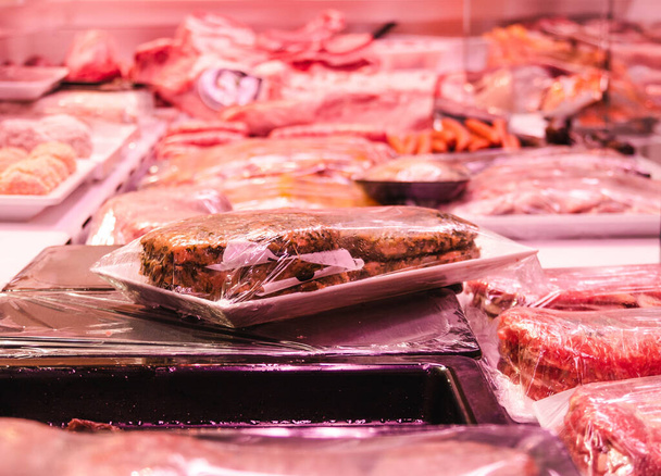 A closeup of meat in the plastic package on the scales in a shop window - Valokuva, kuva