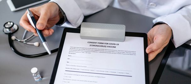 Unrecognizable doctor showing consent form for coronavirus vacci - Photo, Image