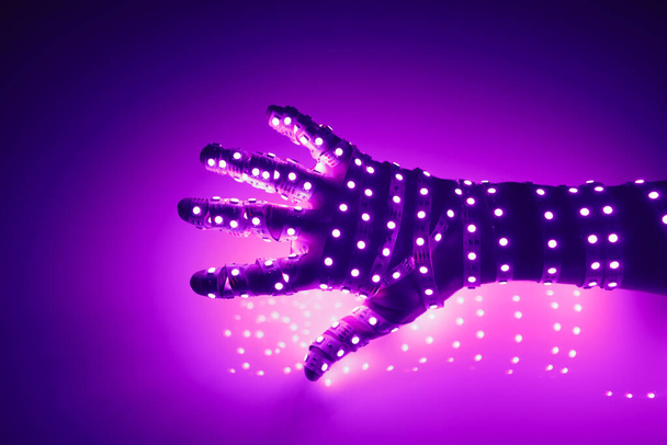 main humaine recouverte de lumières LED violettes, fond lumineux - Photo, image