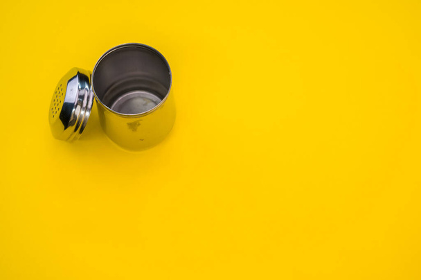 Eine Draufsicht auf einen Shaker für verschiedene Puder auf gelbem Hintergrund - Foto, Bild