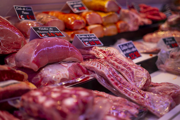 Fresh raw different meat slices on a butcher shop shelf with price tags - Foto, Imagem
