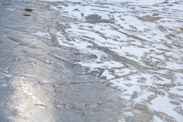 Buz ve beyaz karla kaplı donmuş suyun desenli kış yüzeyi - Fotoğraf, Görsel