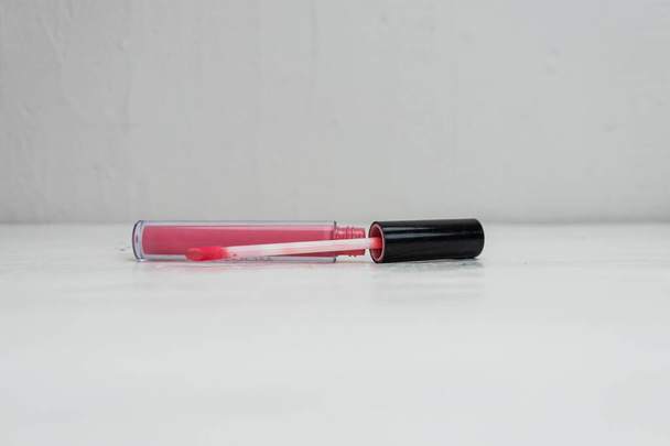 Vloeibare lippenstift met applicator geïsoleerd op wit met kopieerruimte. - Foto, afbeelding