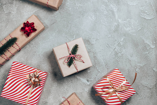 Veselé vánoční přání nebo prapor z dárkových krabic, jedle, dekorace, jiskry na šedém pozadí. Byt ležel, horní pohled - Fotografie, Obrázek