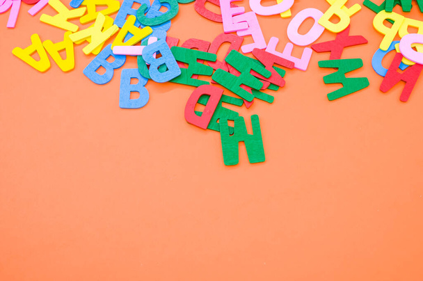 A top view closeup of the letters of the English alphabet isolated on an orange background - 写真・画像