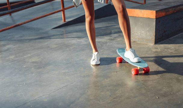 Zdjęcie kobiety łyżwiarki z deskorolką w skateparku - Zdjęcie, obraz