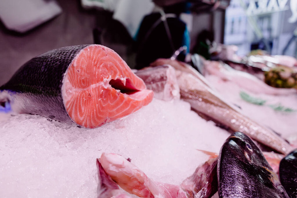 A selective focus shot of freshly sliced salmon on ice displayed in a marketplace - Valokuva, kuva
