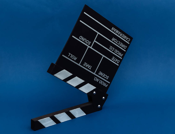 Tablero de aplausos de película sobre fondo azul clásico. Industria cinematográfica, entretenimiento - Foto, imagen