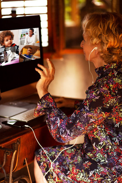 Starší žena se setkává se svými vnoučaty online. Smíšené rasové druhy, a pes mluvící na video hovor s babičkou. - Fotografie, Obrázek