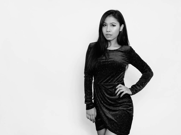 Beautiful asian woman with long black hair posing in dress on grey background - Foto, afbeelding