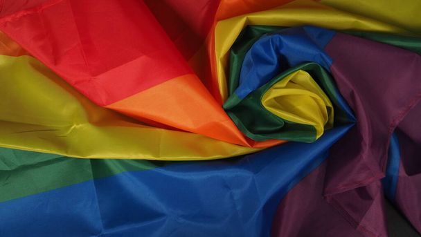 LGBTQ vlag of Lesbian Gay Bi sexsuele Transgender Queer of homoseksuele trots Regenboog vlag op zwarte achtergrond. Vertegenwoordigen hand symbool van vrijheid, vrede, gelijkheid en liefde. LGBTQ-concept - Foto, afbeelding