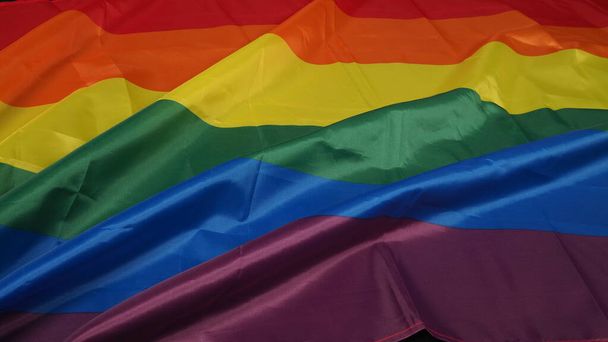 Bandera LGBTQ o Lesbiana Gay Bi sexsual Transgénero Queer o orgullo homosexual Bandera arco iris sobre fondo negro. Representar la mano símbolo de libertad, paz, igualdad y amor. Concepto LGBTQ - Foto, Imagen