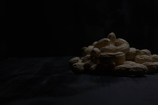 Cacahuetes en una superficie negra - Foto, imagen